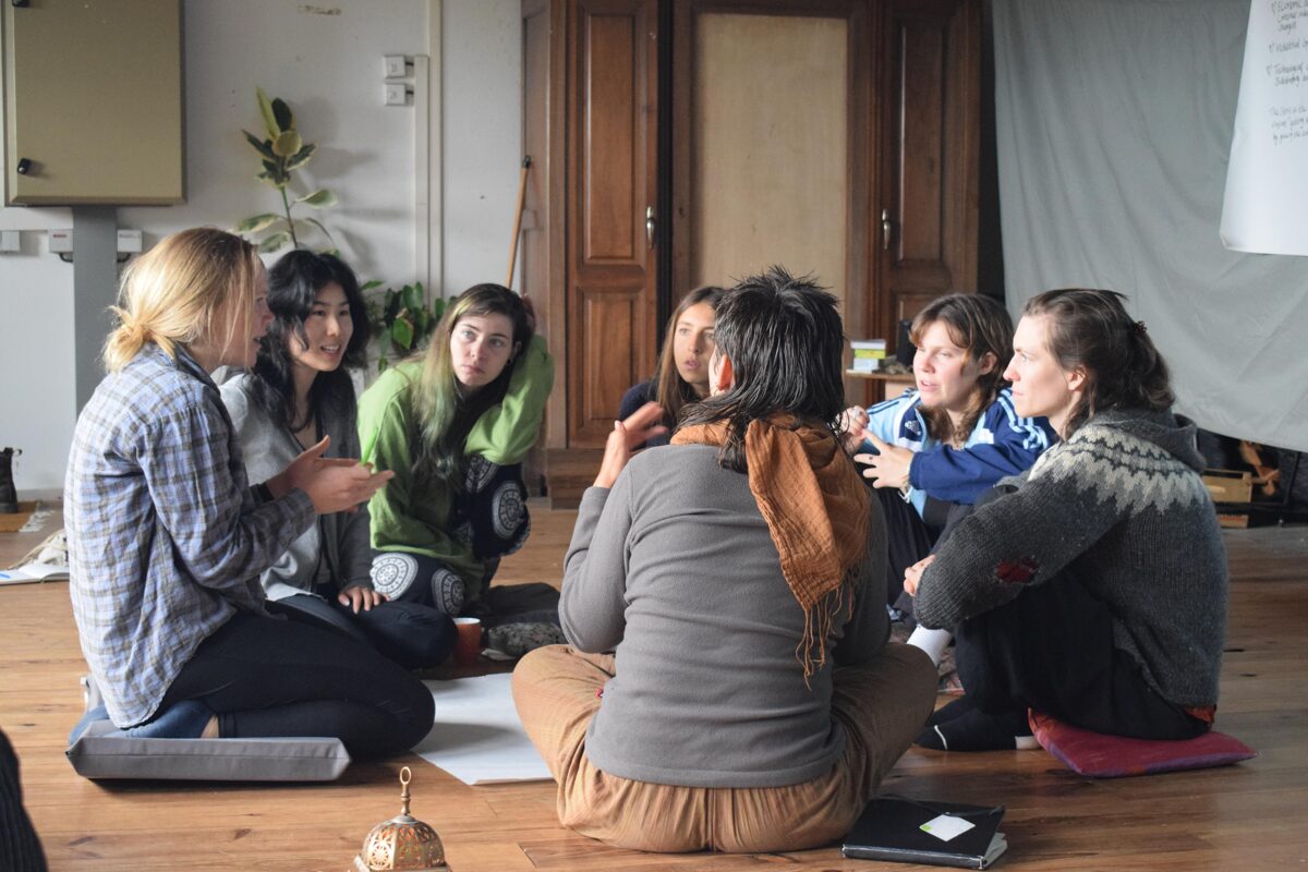 Junge Menschen sitzen im Kreis und diskutieren. Sie nehmen am Jugendaustausch SOLACE teil. EuroYouth Germany.